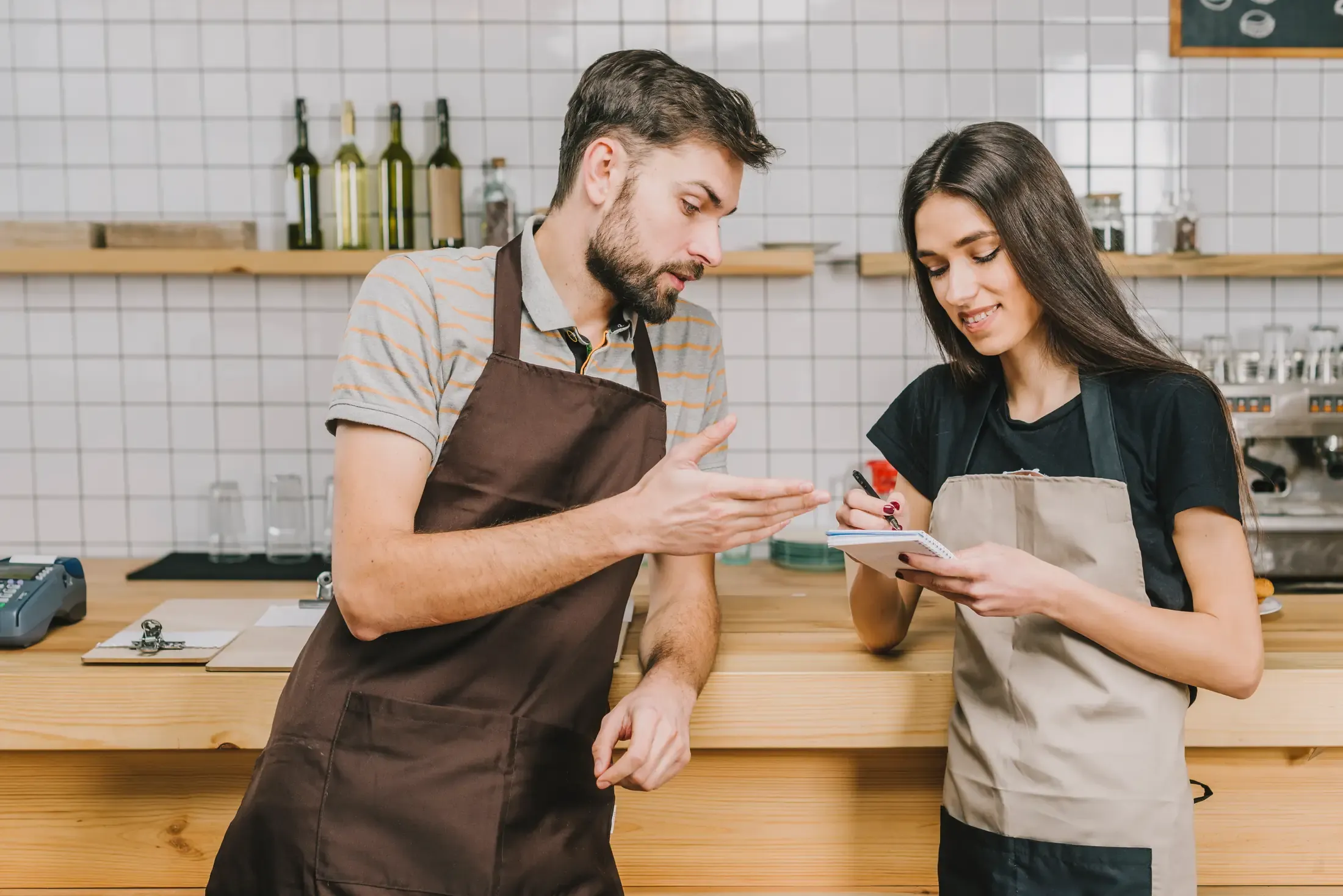 Restaurant staff reviewing shift notes at the counter
